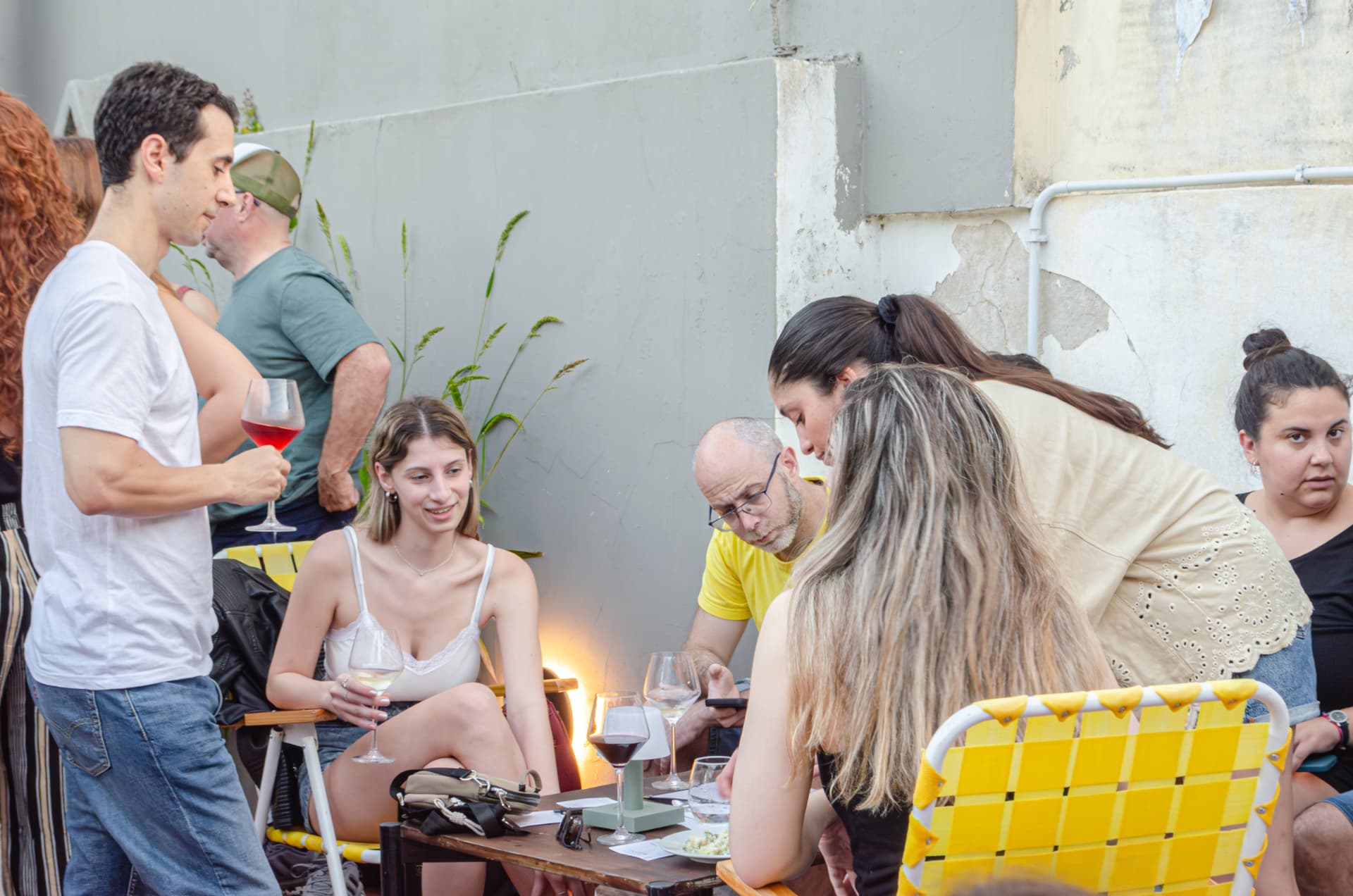 Equipo compartiendo una mesa con vino y picadas en un patio